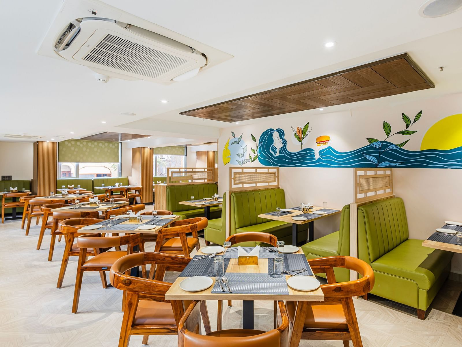 Lemonridge Hotels, KPHB | Dining area with tables and chairs, showcasing the artistic wall decor and ceiling design.